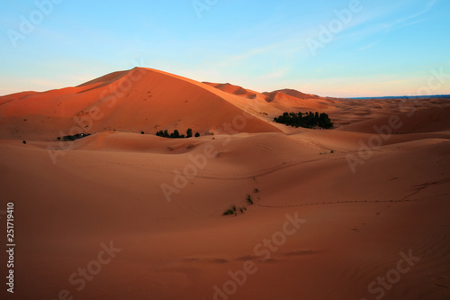 Sun rising on the big sand dune in Sahara desert Merzouga Morocco Africa