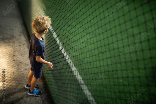 Young boy with big dreams watching a soccer game at the footsal / indoor soccer field