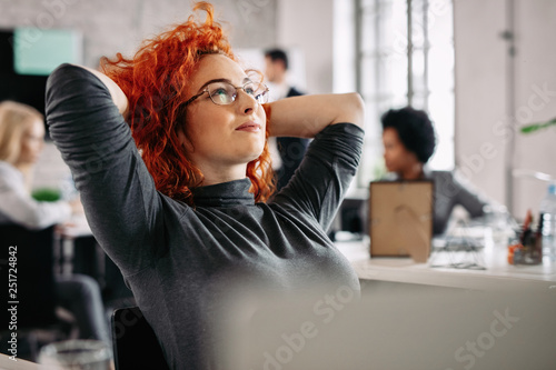 Tableau sur toile Young pensive businesswoman day dreaming in the office.