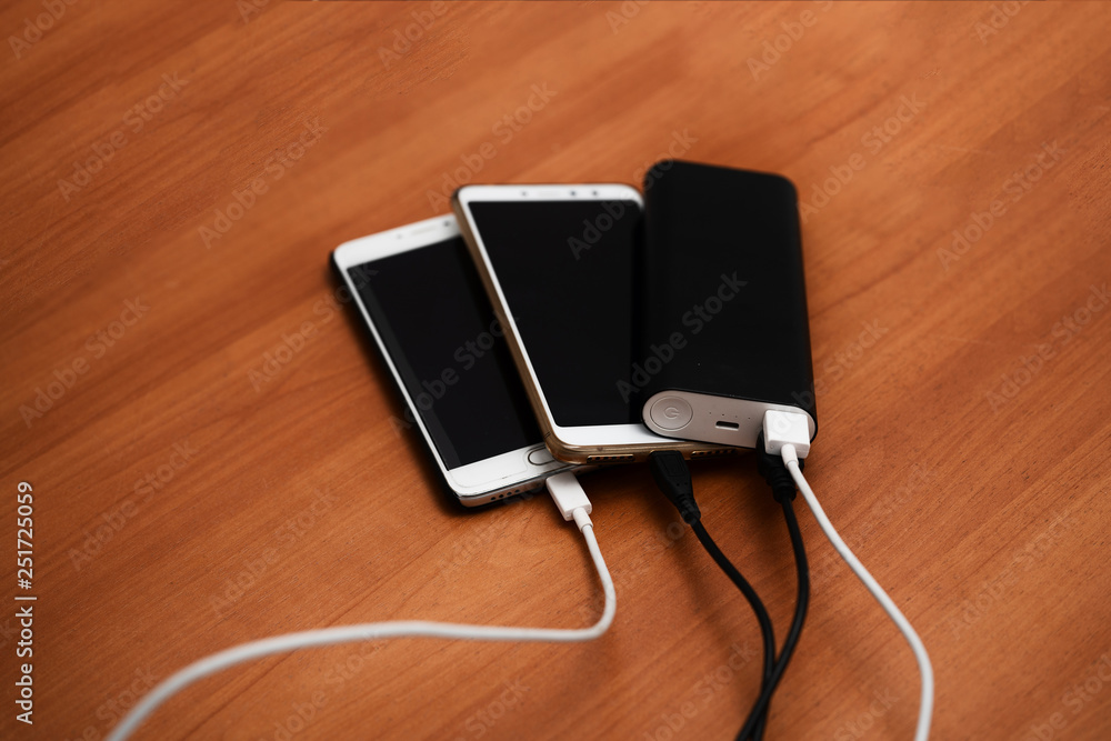 Smartphones are charged from the battery and lie on top of each other. Charger for phone with connected USB cables, wires with smartphones. Template for the designer. Smartphones are charged from the battery and lie on top of each other. Charger for phone with connected USB cables, wires with smartphones. Template for the designer.