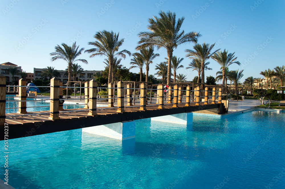 Swimming pool and palm trees  in luxury  hotel 