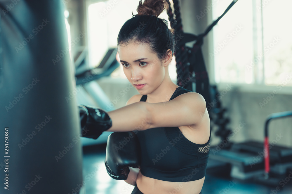 Fototapeta premium Sporty Boxer is Exercise Punching in Fitness Gym.,Portrait of Boxing Woman is Practicing Footwork in Sportswear and Boxing Gloves., Handsome Man is Doing Exercise Punching With Training Bag.