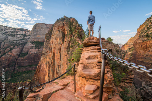 Mid 20's White Male Tourist Standing with confidence on  Angel's Landing Trail with vista. Back Turned no face visible. Zion National Park, Utah