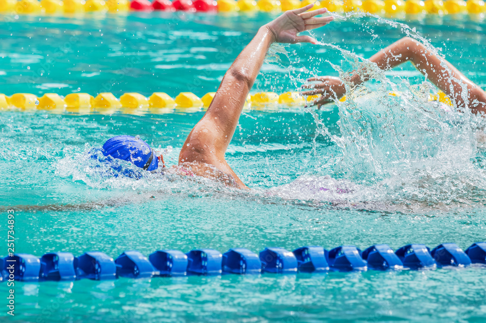 Movement of athletic female swimmers swimming freestyle stroke front crawl or forward crawl during competition in to the pool