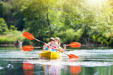 Child on kayak. Kids on canoe. Summer camping.