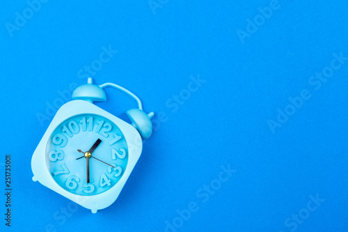 Alarm clock on color background. Pastel minimalism. Copy space