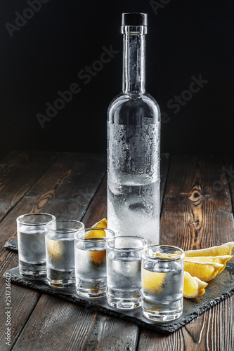 Photo Vodka in shot glasses on rustic wood background