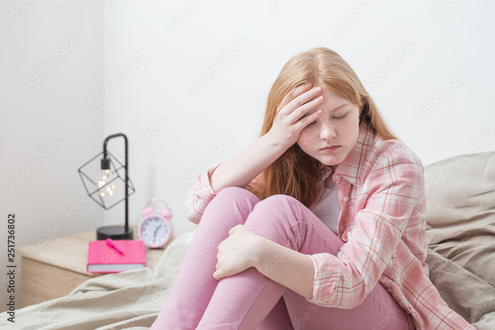 teenager girl with headache in bedroom teenager girl with headache in bedroom
