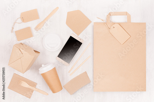 Mockup food takeaway packaging for cafe and restaurant -   phone, bag, cardboard box for coffee,  noodles on light white wood table.