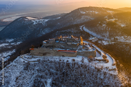 Visegrad, Hungary - Aerial view of the beautiful old and snowy high castle of Visegrad at sunrise on a winter morning photo