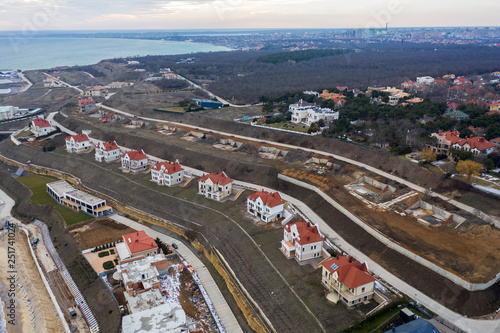 Panoramic aerial view of the cottage settlement by sea. Top view of the marine cottage village, line of strengthening the coast in zone of landslide. Villa on the sea panoramic view from height