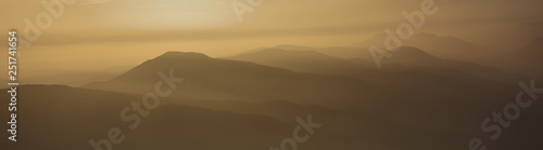 Layered mountains in warm light of sunset © shoricelu