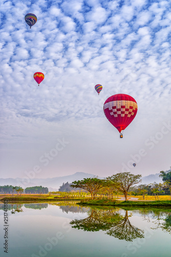 Colorful hot air balloons floating above the lake in Chiang Rai, Thailand