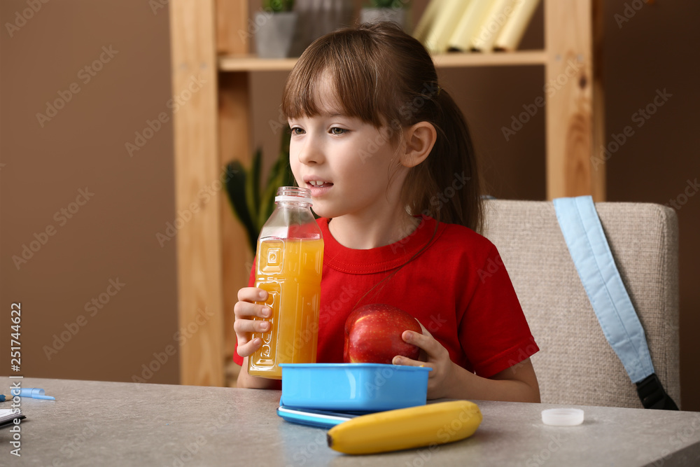 Little girl having school lunch in classroom