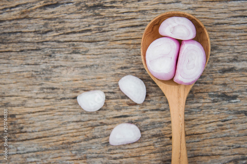 peeling red shallot on wooden table 