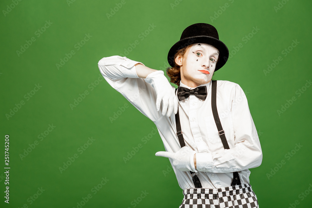Portrait of an actor as a pantomime with white facial makeup posing with expressive emotions isolated on the green background Portrait of an actor as a pantomime with white facial makeup posing with expressive emotions isolated on the green background