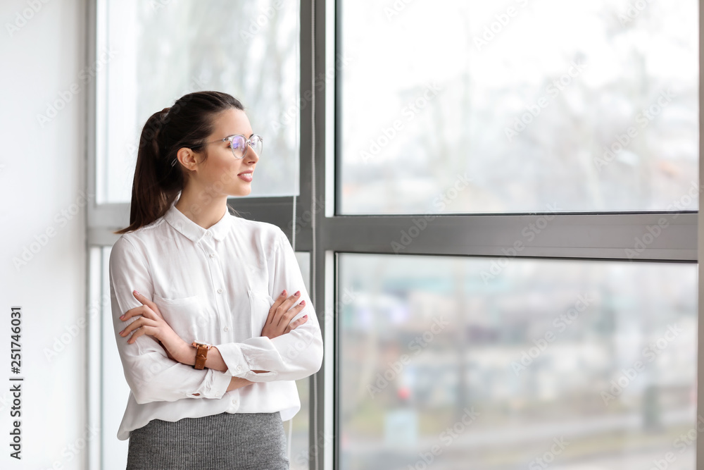 Portrait of young businesswoman near window in office Portrait of young businesswoman near window in office