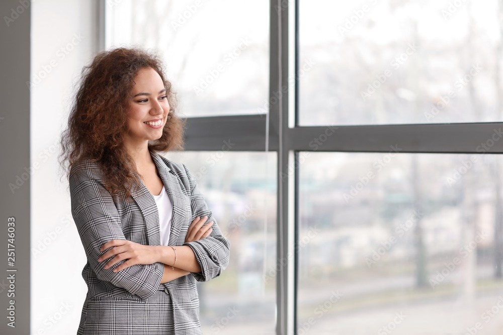 Portrait of young businesswoman near window in office