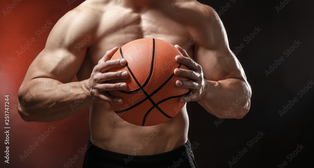 Muscular bodybuilder with ball on dark background Muscular bodybuilder with ball on dark background