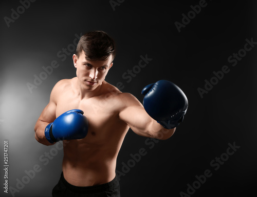 Attractive young boxer on dark background © Pixel-Shot