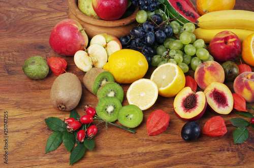 Fototapeta Naklejka Na Ścianę i Meble -  A variety of fruits on the dishes on the table. Grapes, peaches, apples, lemon, orange, pomegranate, pears, plums.