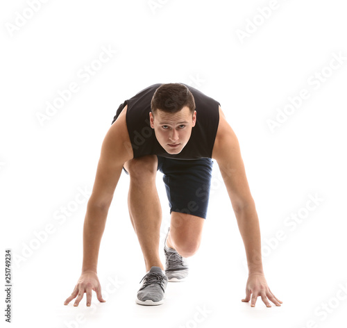 Sporty young man in crouch start position against white background