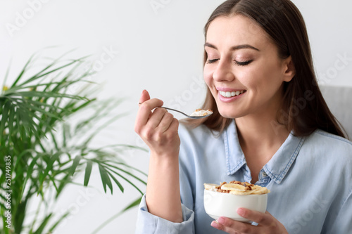 Young woman eating tasty yo...