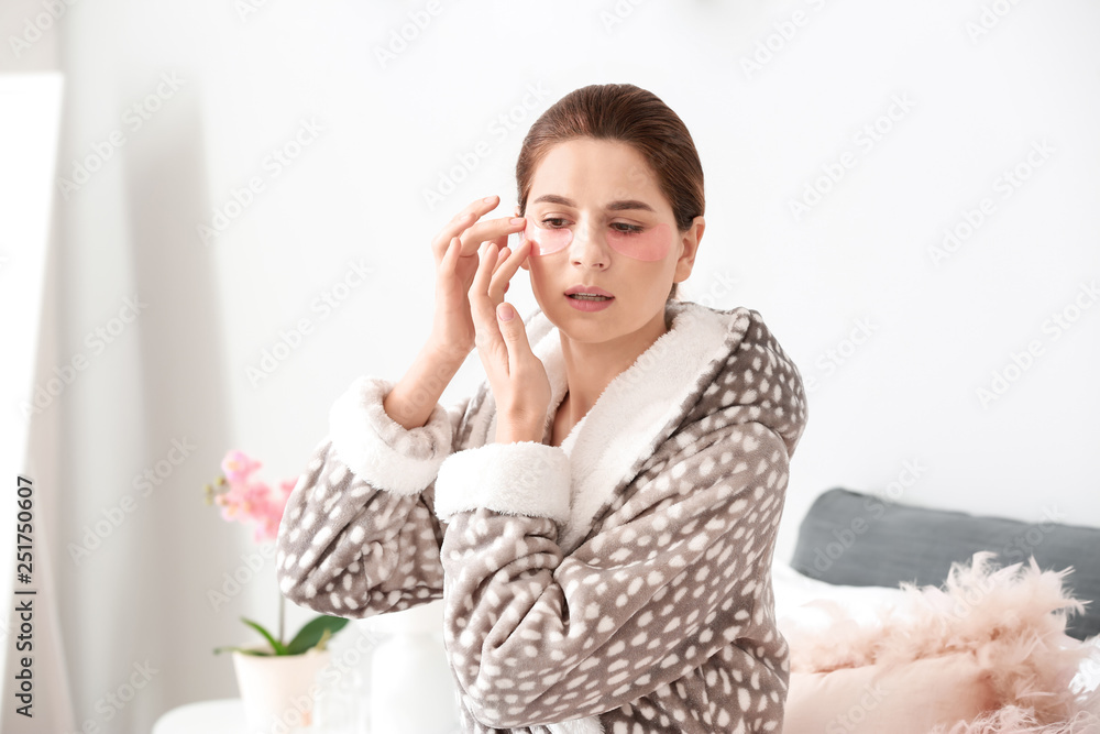 Woman applying under-eye patches at home Woman applying under-eye patches at home