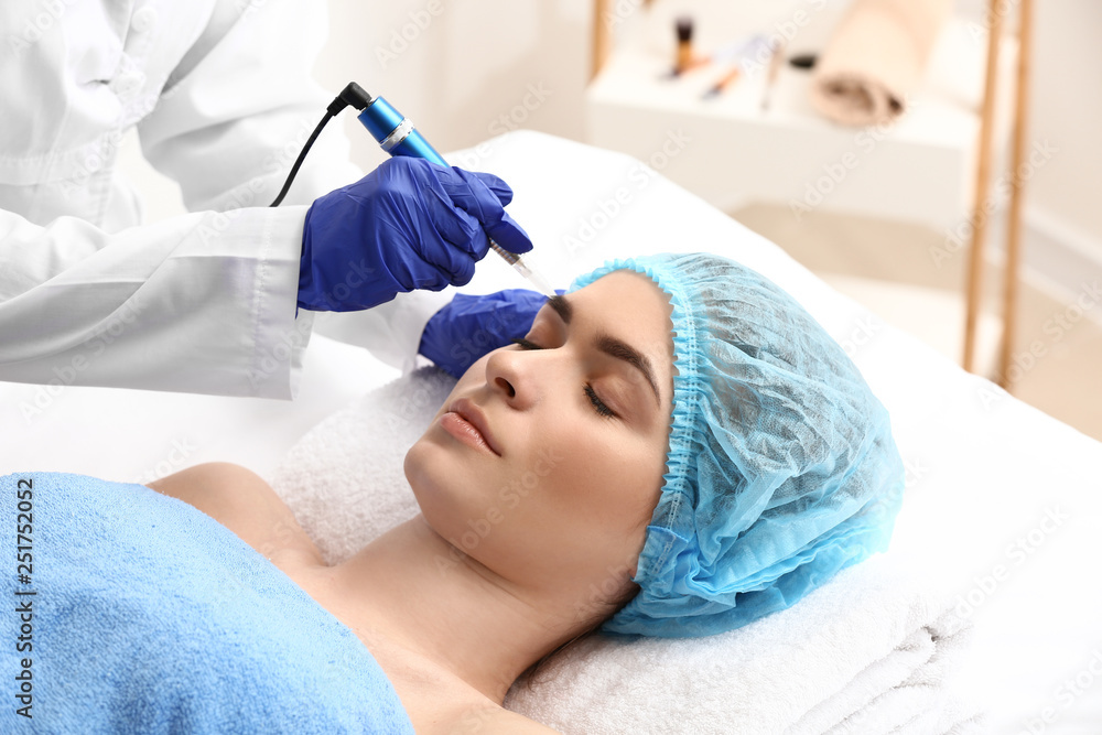 Young woman undergoing procedure of eyebrow permanent makeup in beauty salon Young woman undergoing procedure of eyebrow permanent makeup in beauty salon