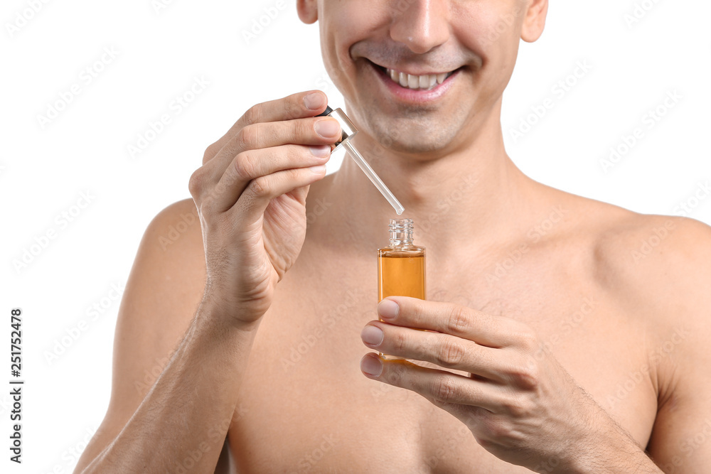 Fototapeta premium Handsome man with face serum on white background