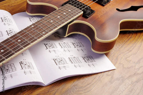 Electric guitar and an open book with guitar chords.