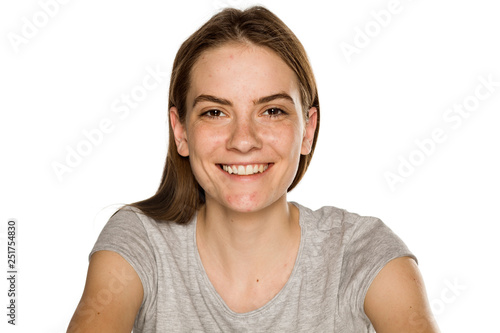 Young smiling woman without makeup on white background