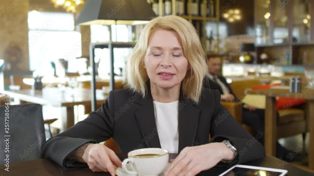 Lockdown of Caucasian woman in office clothes sitting in café and talking with partner via internet Lockdown of Caucasian woman in office clothes sitting in café and talking with partner via internet