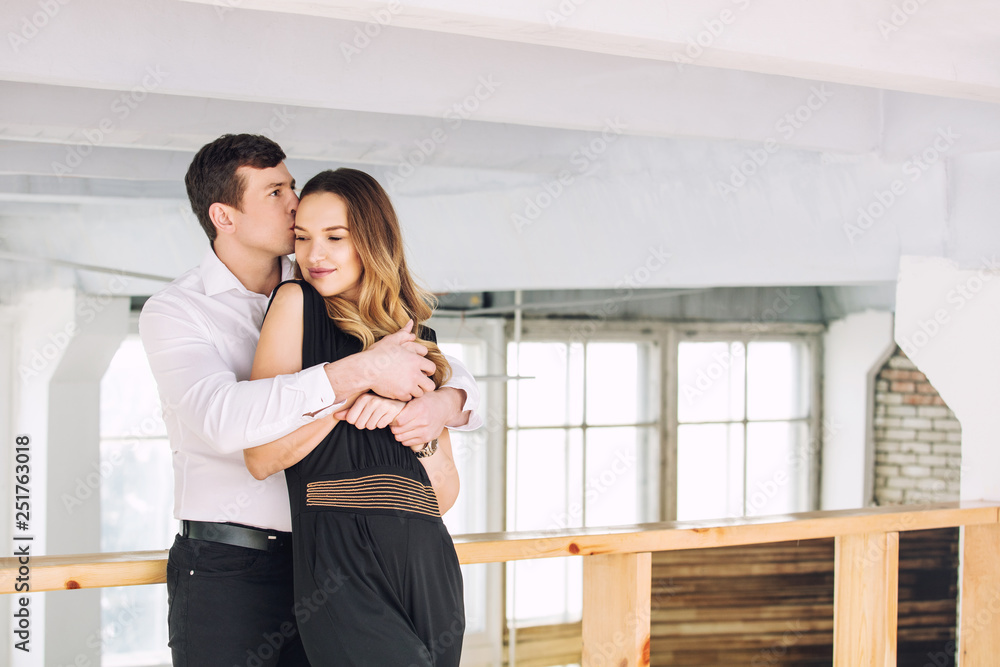 Young adult beautiful couple man and woman happy together in loft style interior Young adult beautiful couple man and woman happy together in loft style interior