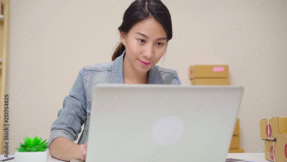 Beautiful smart Asian young entrepreneur business woman owner of SME online checking product on stock and save to computer working at home. Small business owner at home office concept. Beautiful smart Asian young entrepreneur business woman owner of SME online checking product on stock and save to computer working at home. Small business owner at home office concept.