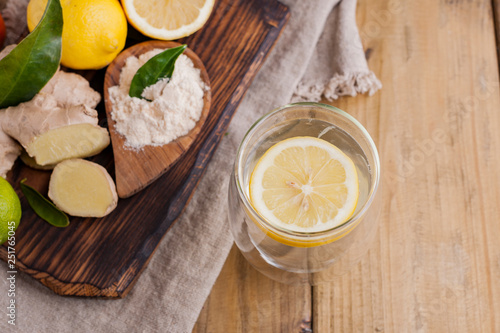 ginger, lemon and glass on a wooden background, Photo in rustic style. Ingredients for warming and health drink. Alternative medicine. Free space for text.