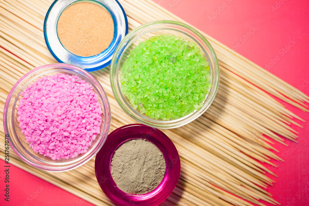 Naklejka premium Spa concept. Pink and green salt inside the glass. Blue and red clay. Top view. Space for your text.