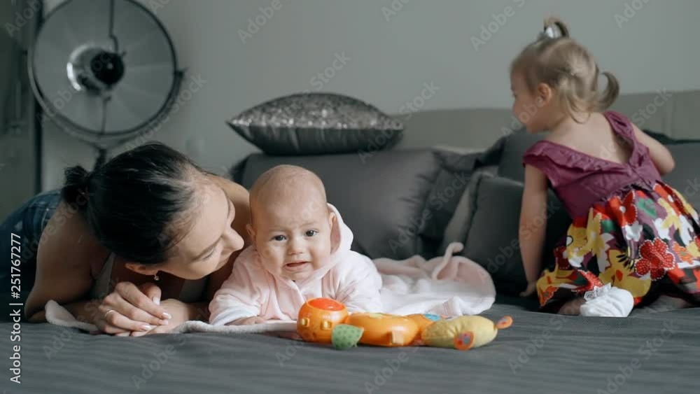 Young mother spending time with two children in the bedroom. Young mother spending time with two children in the bedroom.