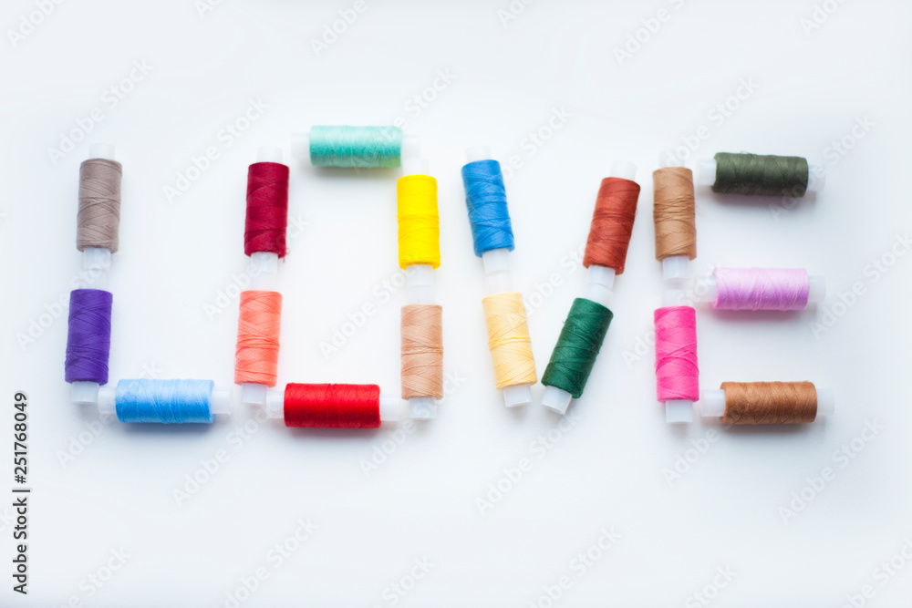 Spool of colorful threads on the white background. Top view. Space for your text. Spool of colorful threads on the white background. Top view. Space for your text.