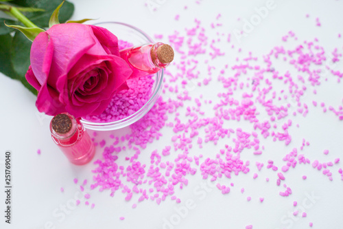 Fototapeta Naklejka Na Ścianę i Meble -  Aromatherapy. Small glass bottles with cosmetic oils. Sea salt. Fresh pink rose. Ingredients  for spa procedures on white background. Body care, skin care. Close up.