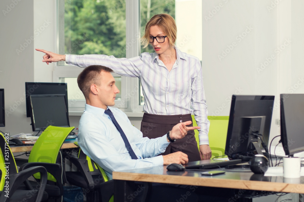 You're fired. A female supervisor shows an employee who wants to dismiss an employee in the direction of exit. Negative conversation of two people in the office near the workplace. You're fired. A female supervisor shows an employee who wants to dismiss an employee in the direction of exit. Negative conversation of two people in the office near the workplace.