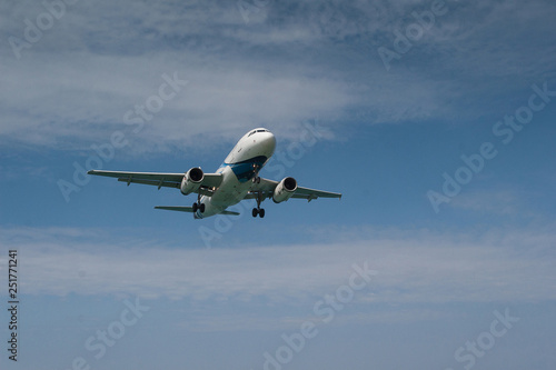 Passenger plane in the blue sky with clouds landing at Mai Khao airport in Thailand