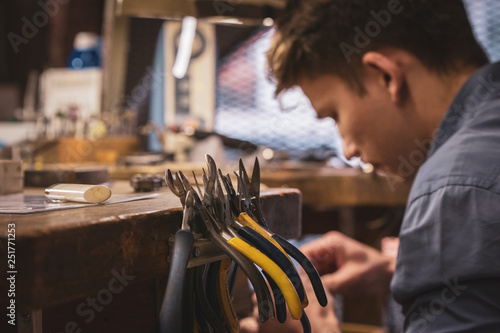Craftman working on a wooden work bench with tools