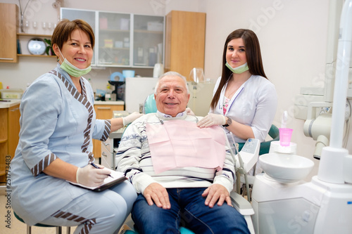 Happy senior man 70-75 years old sitting in dental office after teeth check