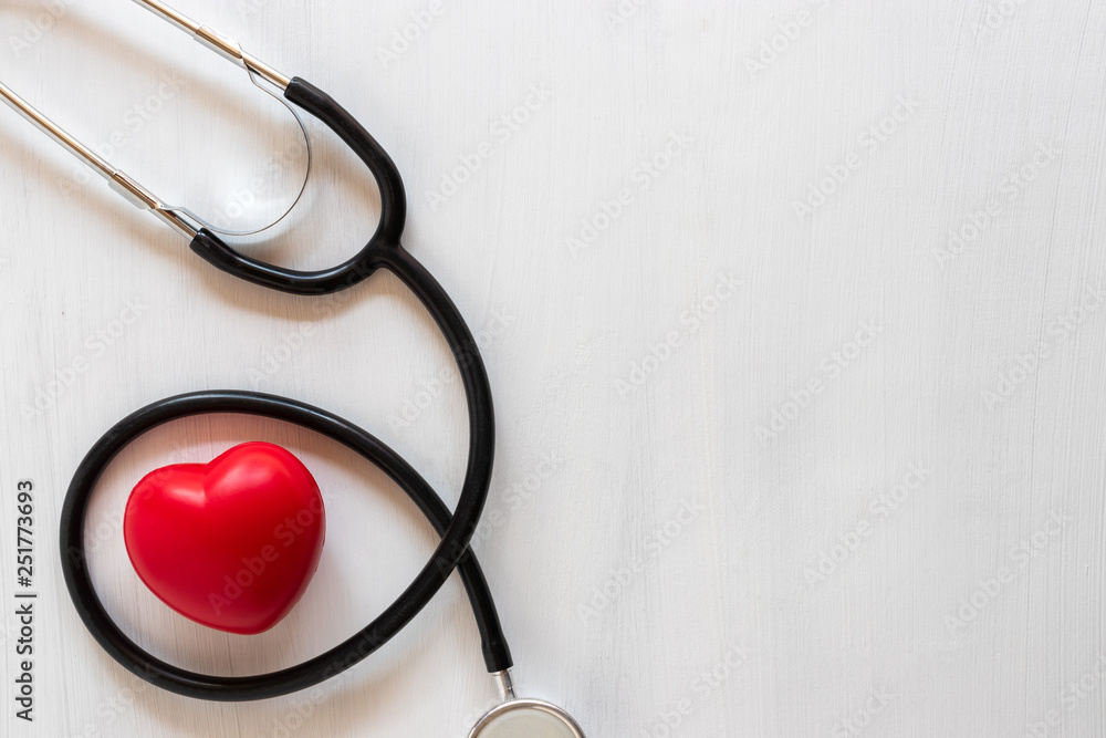 Stethoscope and heart on wooden background. Health care concept