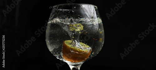 Kiwi in a glass with water splash  black background