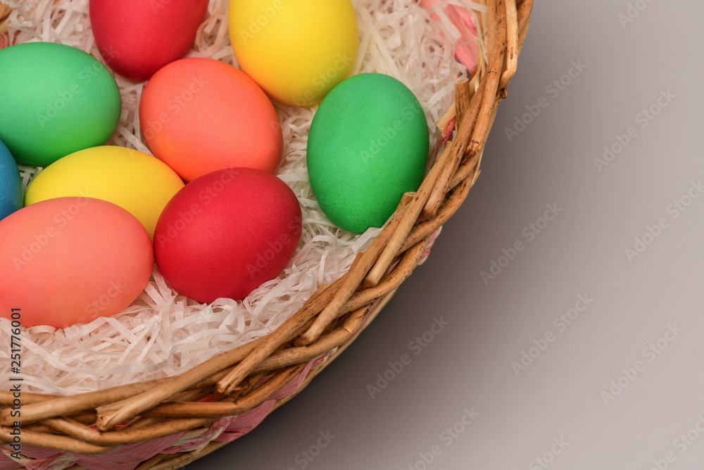Left a basket of colored Easter eggs on the right a blank space for the label, copyspace. Horizontal photography