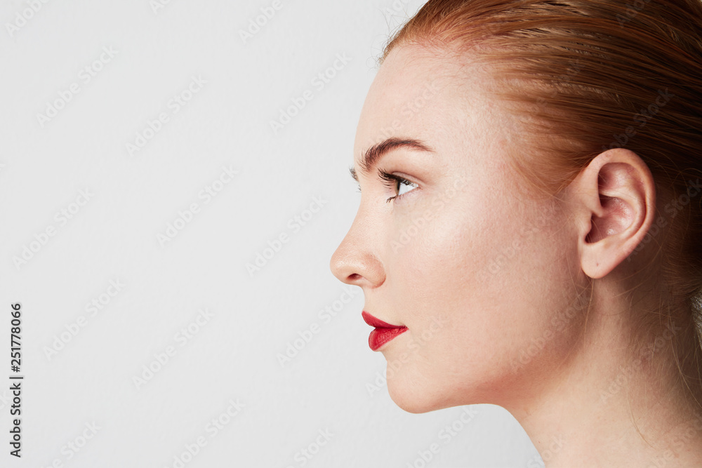 Profile portrait of beauty female redhead model with dark eyebrows and light nude make-up. Copy paste place Profile portrait of beauty female redhead model with dark eyebrows and light nude make-up. Copy paste place