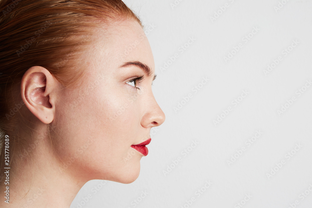 Profile portrait of beauty female redhead model with dark eyebrows and light nude make-up. Copy paste place Profile portrait of beauty female redhead model with dark eyebrows and light nude make-up. Copy paste place