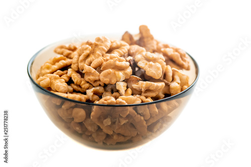 Studio photo of bowl with heap of peeled walnuts isolated on white